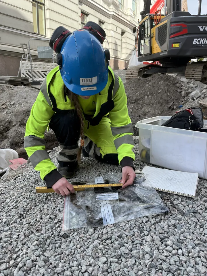 Arkelogen måler lengden på en skosåle til barn.