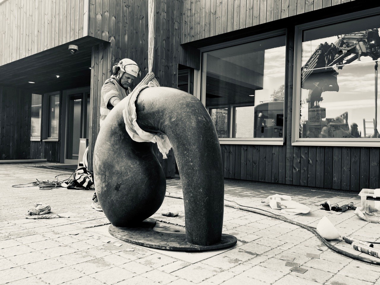 En mann monterer skulpturen.