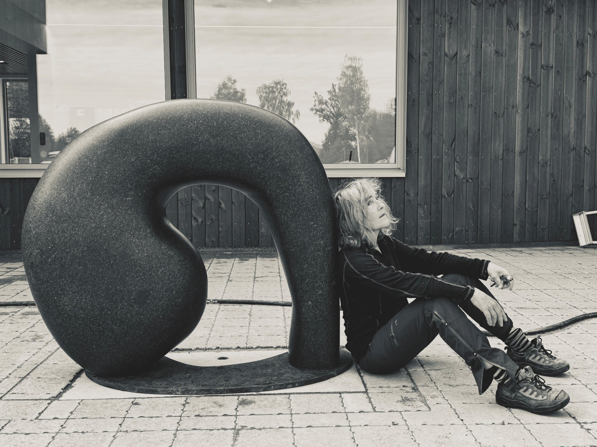 skulptur og kvinne som lener seg mot den.