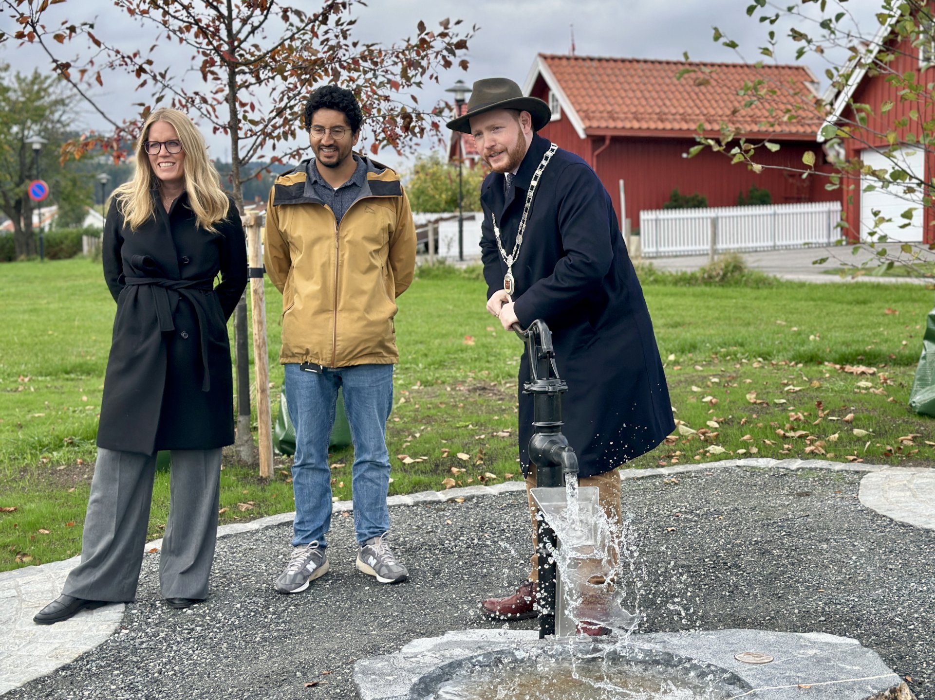 ordfører starter vannpumpa mens prosjektlederne står ved siden av
