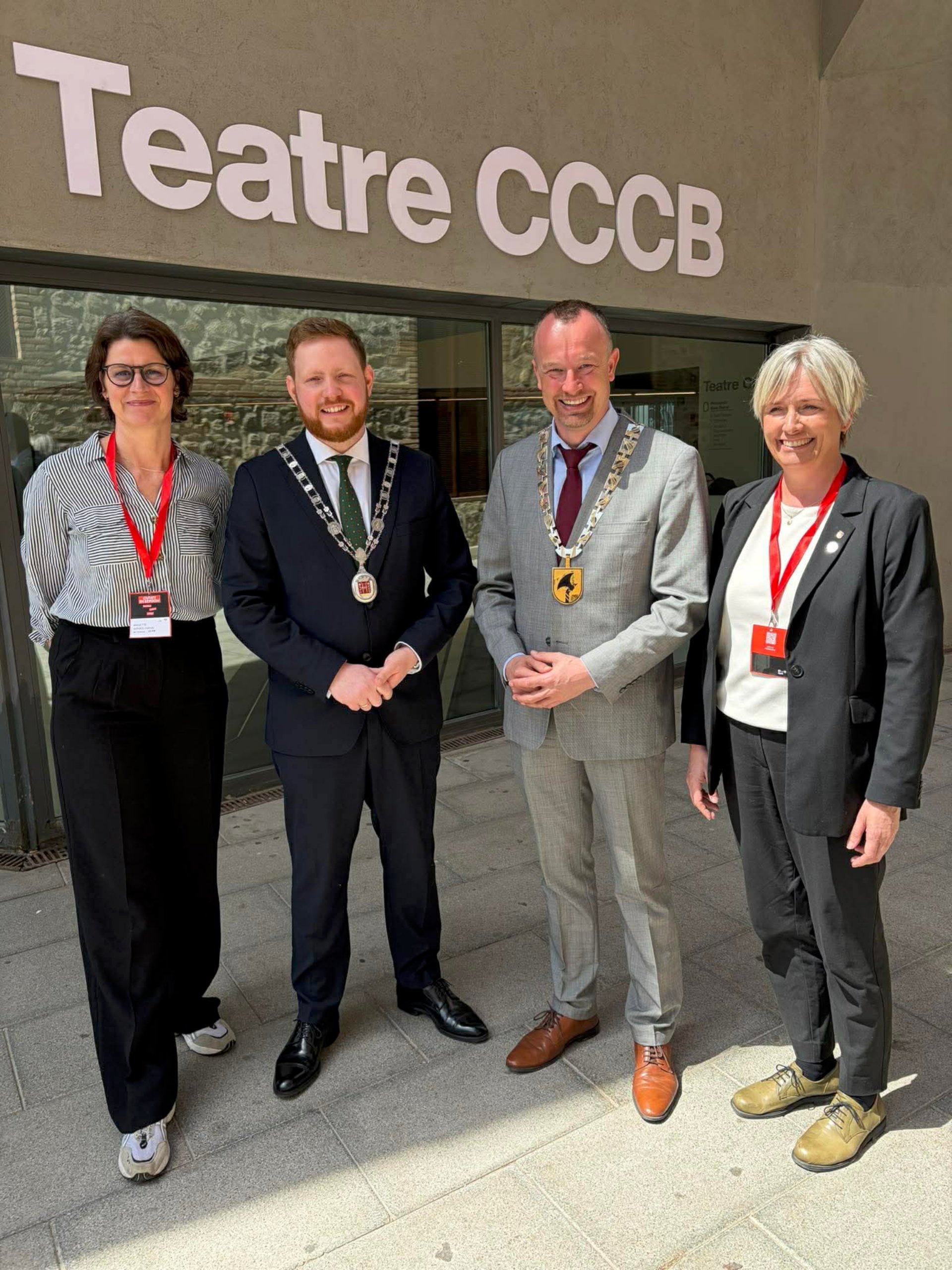 Fire personer står utenfor et bygg