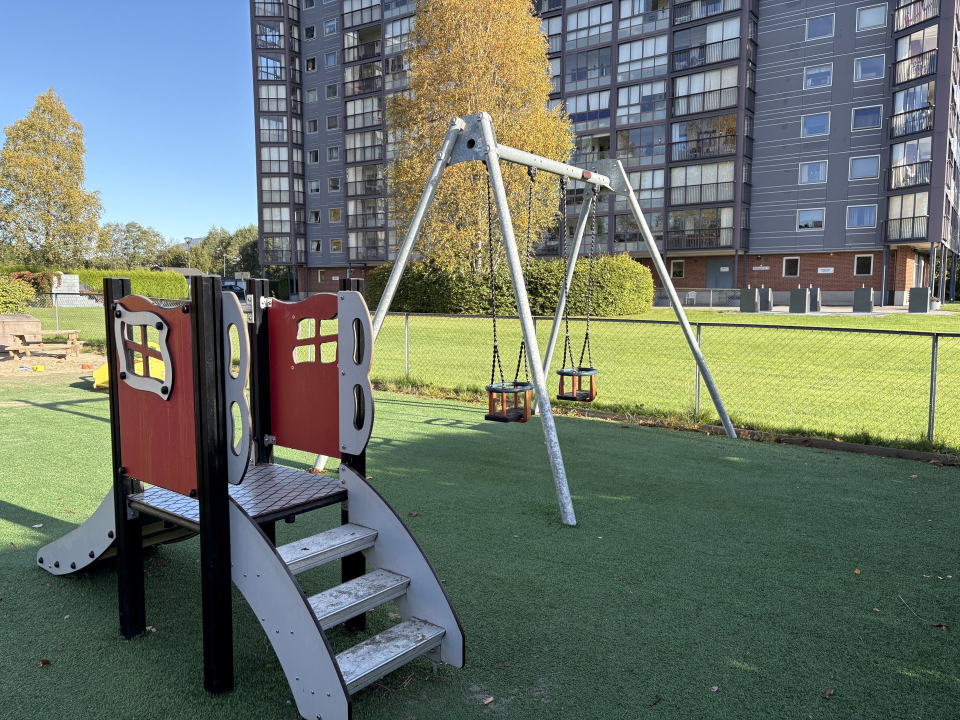 lekeområde med huskestativ og sklie