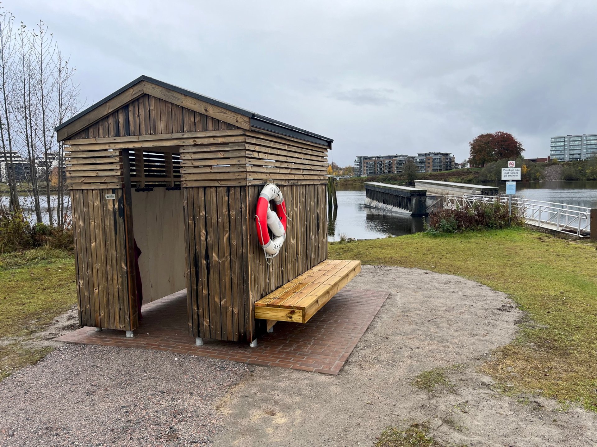 Lite trehus på et område ved vannet.