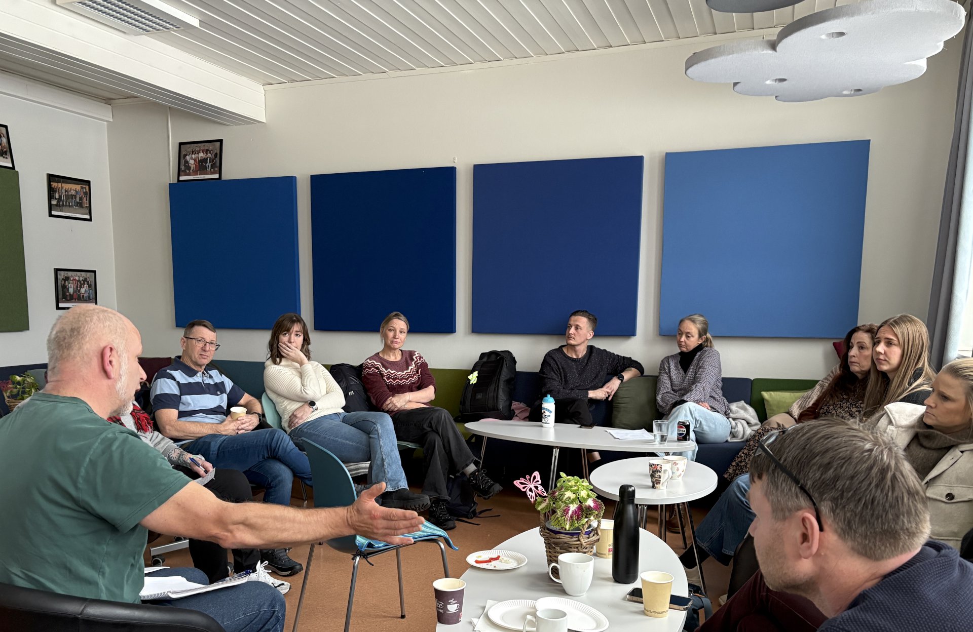 mennesker sitter i et rom og diskuterer