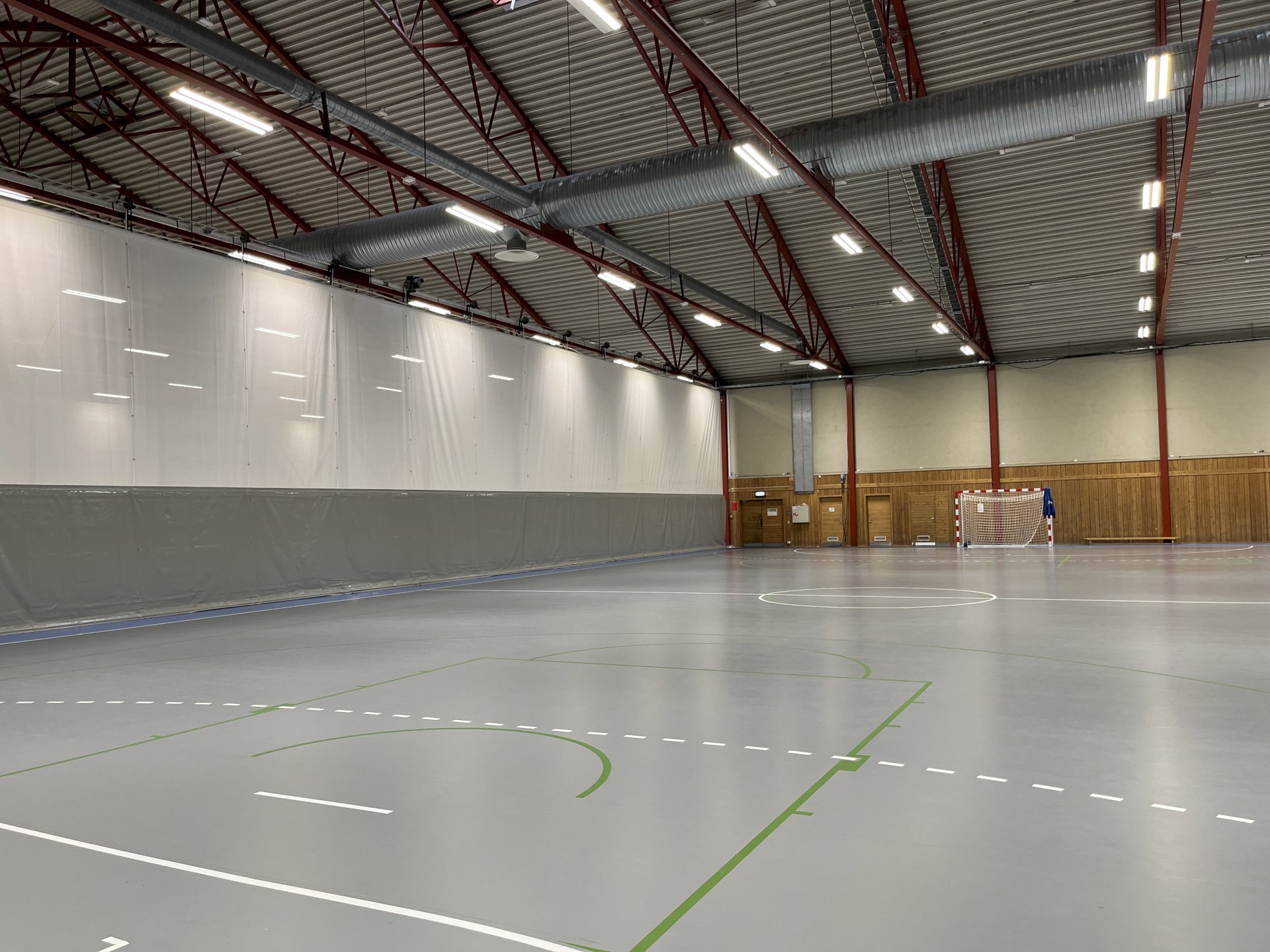 En idrettshall med skillevegger og håndballmål.