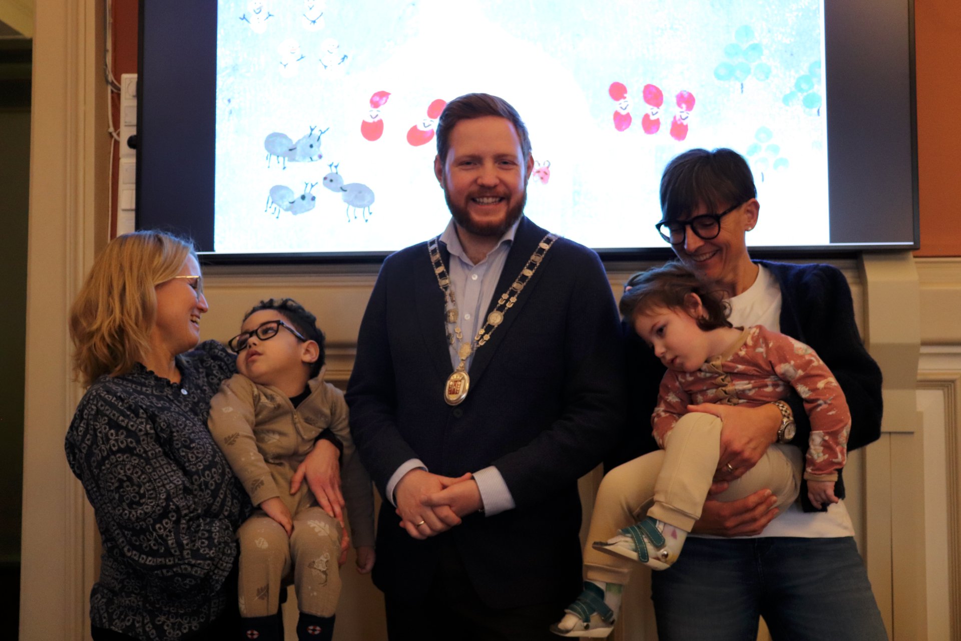 To barn som har vunnet en tegnekonkurranse, sammen med ordfører og to lærere