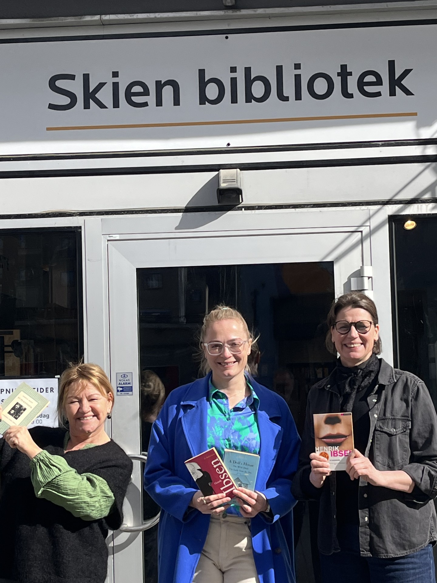 Helle Riis (t.v.), Julie Nordahl og Annette Winkelmann i Sølvåren Ibsen formidlingssenter er glade for tildelinga fra UNESCO. Bildet er tatt utenfor Skien bibliotek.