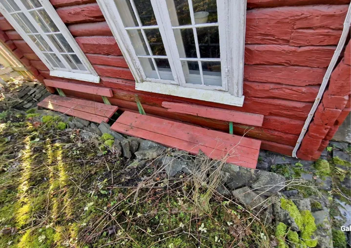 Et rødt hus med høyt gress