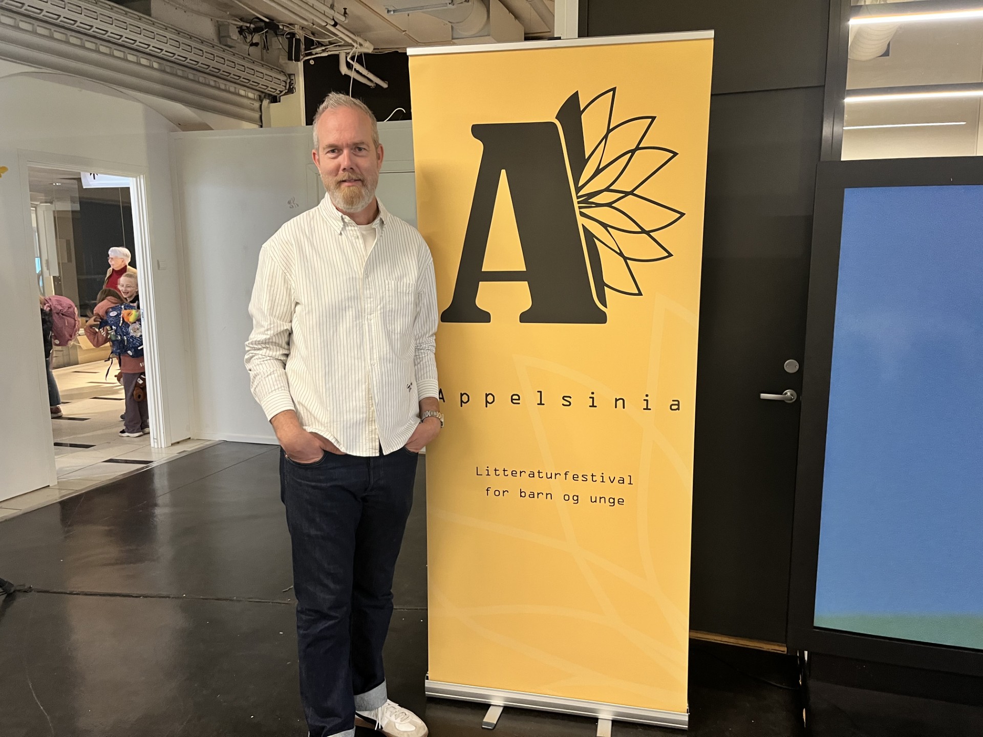 Terje Solli poserer foran en roll-up med Appelsinia-logo.