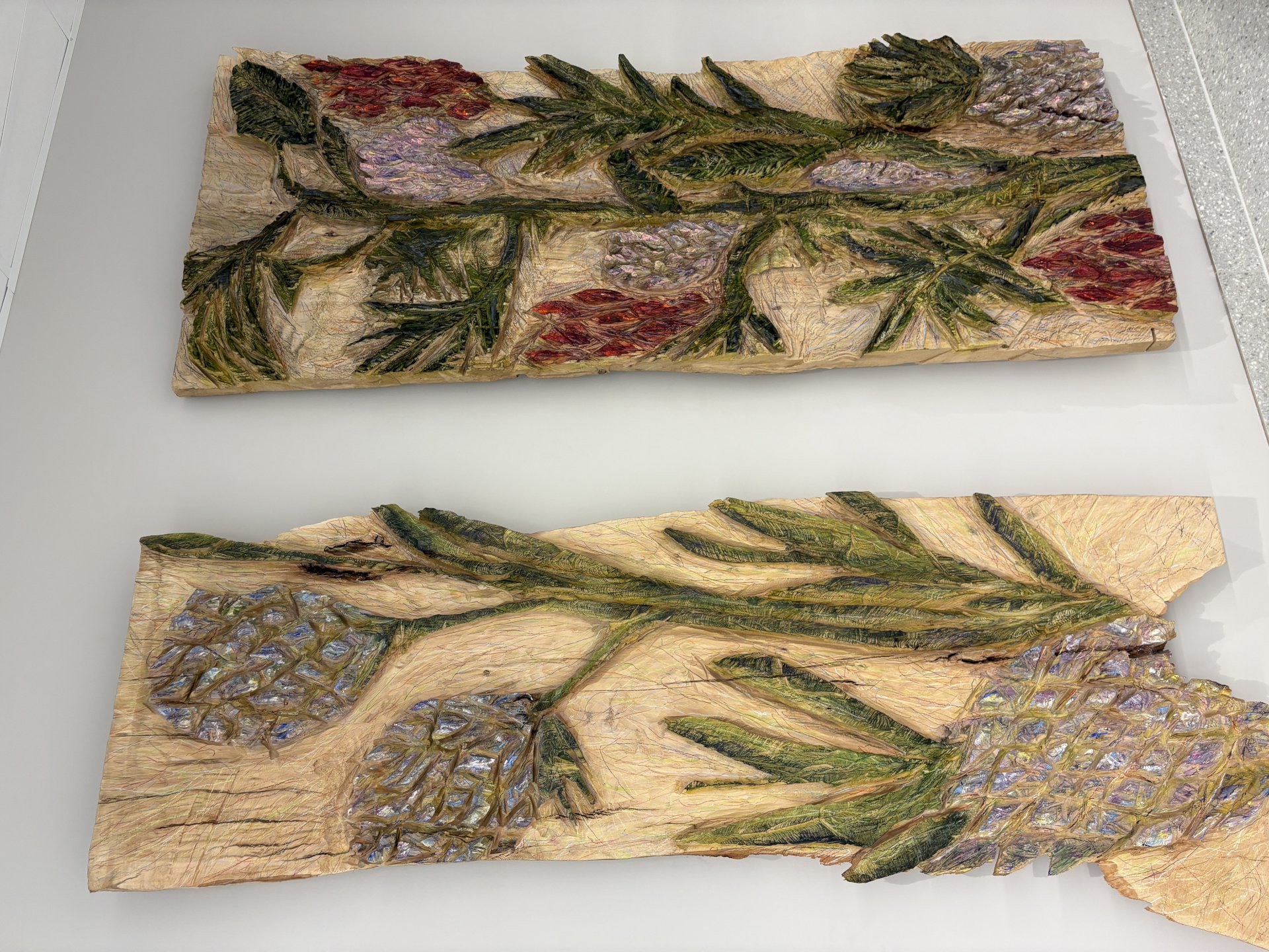 Treplater hvor det er skåret ut blomstermotiv som er malt i grønt, lilla og rødt.