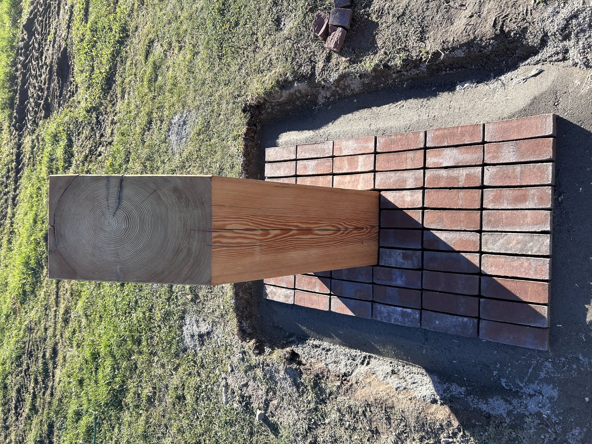 Trestolpe som står på et lite område med teglstein.